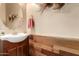 Stylish powder room featuring modern wood paneling, a sleek sink and vanity, and decorative wall art at 20962 W Thomas Rd, Buckeye, AZ 85396