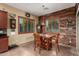 Cozy dining area with wood-look flooring, complemented by natural light streaming through shuttered windows and wood accent wall at 20962 W Thomas Rd, Buckeye, AZ 85396