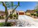 Charming single-story home featuring a tile roof, mature landscaping, and a spacious driveway leading to a two-car garage at 20962 W Thomas Rd, Buckeye, AZ 85396