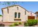 Charming single-story home highlighting arched windows, manicured landscaping, and a secure home monitoring system at 20962 W Thomas Rd, Buckeye, AZ 85396