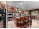 Open kitchen with stainless steel appliances, granite countertops, mosaic backsplash and a central island with bar seating at 20962 W Thomas Rd, Buckeye, AZ 85396