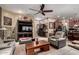 Comfortable living room featuring a ceiling fan, tile flooring, and an entertainment center with ample seating at 20962 W Thomas Rd, Buckeye, AZ 85396
