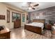 Comfortable primary bedroom features natural light and wood accent wall, offering a serene retreat at 20962 W Thomas Rd, Buckeye, AZ 85396