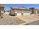 Side view of a cozy single Gathering house featuring a 2-car garage, desert landscaping, and driveway at 2101 S Meridian Rd # 199, Apache Junction, AZ 85120