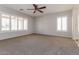 Spacious main bedroom with carpeting, ceiling fan, and large windows for natural light at 23162 W Lasso Ln, Buckeye, AZ 85326