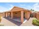 Covered patio with ceiling fan, and desert landscaping provides a relaxing outdoor living space at 23162 W Lasso Ln, Buckeye, AZ 85326