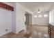 Sun-lit sun room with access to laundry room, stone flooring, and modern light fixtures at 23162 W Lasso Ln, Buckeye, AZ 85326