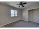 Bedroom with new carpet, ceiling fan, and a window with neighborhood views at 2627 W Buckskin Trl, New River, AZ 85087