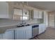 Kitchen with stainless steel dishwasher, white cabinets and countertops at 2627 W Buckskin Trl, New River, AZ 85087