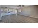 Bright, open living room with a ceiling fan and new laminate floors adjacent to kitchen at 2627 W Buckskin Trl, New River, AZ 85087