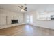 Open-concept living space featuring a brick fireplace, wood-look floors, and a modern kitchen at 2728 W Redfield Rd, Phoenix, AZ 85053