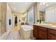 This bathroom offers a soaking tub with tile surround, dual sinks and glass block window at 27308 N 56Th Dr, Phoenix, AZ 85083