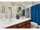 Bright bathroom features dual sinks with dark wood cabinets and decorative flower arrangement at 27308 N 56Th Dr, Phoenix, AZ 85083