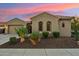 Charming home exterior with desert landscaping and warm lighting under a colorful sky at 27308 N 56Th Dr, Phoenix, AZ 85083
