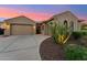 Warm home exterior with well-maintained desert landscaping illuminated against a sunset sky at 27308 N 56Th Dr, Phoenix, AZ 85083
