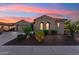 Charming home exterior with arched windows, desert landscaping, and a spacious driveway at 27308 N 56Th Dr, Phoenix, AZ 85083