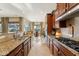 Bright kitchen showcases granite counters, modern appliances, wood cabinets, and view to backyard at 27308 N 56Th Dr, Phoenix, AZ 85083