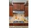 Close-up of a modern gas cooktop with granite countertops and custom wooden cabinetry at 27308 N 56Th Dr, Phoenix, AZ 85083