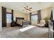 Spacious main bedroom featuring a decorative bed frame, ceiling fan, carpet, and two windows at 27308 N 56Th Dr, Phoenix, AZ 85083