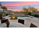 Serene pool area with palm trees, a water feature, and a cozy dining set under a twilight sky at 27308 N 56Th Dr, Phoenix, AZ 85083