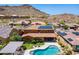 Expansive aerial view of property featuring a backyard swimming pool with desert landscaping and solar panels at 27809 N Silverado Ranch Rd, Peoria, AZ 85383