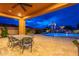 Inviting outdoor space with covered patio, dining area, pool, waterfall feature, and lush landscaping at 27809 N Silverado Ranch Rd, Peoria, AZ 85383
