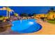 Lush backyard oasis featuring a shimmering pool, cascading rock waterfall, and outdoor entertainment area at 27809 N Silverado Ranch Rd, Peoria, AZ 85383