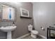 Chic powder room with a pedestal sink, decorative mirror, and stylish accents, offering a touch of elegance at 27809 N Silverado Ranch Rd, Peoria, AZ 85383