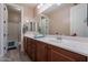 Bathroom featuring double sinks, wood cabinets, framed mirror, and separate shower and tub at 27809 N Silverado Ranch Rd, Peoria, AZ 85383