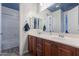 Bathroom featuring double sinks, wood cabinets, framed mirror, and separate shower and tub at 27809 N Silverado Ranch Rd, Peoria, AZ 85383