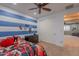 Bedroom decorated with blue and white striped walls, a ceiling fan, closet doors at 27809 N Silverado Ranch Rd, Peoria, AZ 85383