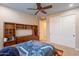 Bedroom with ceiling fan and closet doors with custom-built cabinets at 27809 N Silverado Ranch Rd, Peoria, AZ 85383