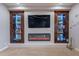 Bedroom featuring built-in wood shelving with blue lighting, a fireplace, and TV on a neutral colored wall at 27809 N Silverado Ranch Rd, Peoria, AZ 85383