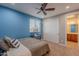 Bright bedroom with blue accent wall, fan, and carpet floor at 27809 N Silverado Ranch Rd, Peoria, AZ 85383