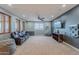 Large bonus room with big windows, theater chairs, ceiling fan, and game storage at 27809 N Silverado Ranch Rd, Peoria, AZ 85383