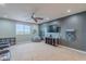 Large bonus room with big windows, theater chairs, ceiling fan, and game storage at 27809 N Silverado Ranch Rd, Peoria, AZ 85383