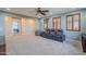 Large bonus room with big windows, theater chairs, ceiling fan, and game storage at 27809 N Silverado Ranch Rd, Peoria, AZ 85383
