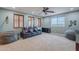 Large bonus room with big windows, theater chairs, ceiling fan, and game storage at 27809 N Silverado Ranch Rd, Peoria, AZ 85383