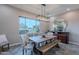 Elegant dining room with rustic wood table, stylish chairs, bench seating, decorative lighting and large windows at 27809 N Silverado Ranch Rd, Peoria, AZ 85383
