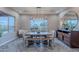 Bright dining room featuring a rustic wood table with bench, stylish chairs, updated lighting, and large bright window at 27809 N Silverado Ranch Rd, Peoria, AZ 85383