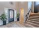 Grand foyer featuring a wrought iron front door, staircase, and stylish wood-look flooring at 27809 N Silverado Ranch Rd, Peoria, AZ 85383