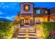 Inviting front entrance with stone accents, illuminated steps, lush landscaping, and a secure front door at 27809 N Silverado Ranch Rd, Peoria, AZ 85383