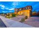 Two-story home with brick and stone accents, lighted entry, manicured lawn, and a three-car garage at 27809 N Silverado Ranch Rd, Peoria, AZ 85383
