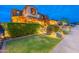 Charming two-story home with manicured lawn, colorful flowers and lighted steps to the front door at 27809 N Silverado Ranch Rd, Peoria, AZ 85383