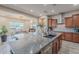 Open kitchen layout with an island, stainless steel appliances, granite counters, and wood cabinets; flows to dining area at 27809 N Silverado Ranch Rd, Peoria, AZ 85383
