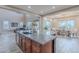Open-concept kitchen island with stone countertops, seamlessly connecting to the living and dining areas at 27809 N Silverado Ranch Rd, Peoria, AZ 85383