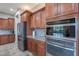 Well-equipped kitchen with stainless steel appliances, granite countertops, and dark wood cabinetry with ample storage at 27809 N Silverado Ranch Rd, Peoria, AZ 85383