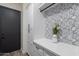 Modern laundry room with custom cabinets, quartz countertop, and stylish patterned tile backsplash at 27809 N Silverado Ranch Rd, Peoria, AZ 85383