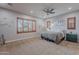 Serene primary bedroom with neutral tones, shutters, carpeted floors, ceiling fan, and ambient recessed lighting at 27809 N Silverado Ranch Rd, Peoria, AZ 85383