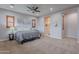 Spacious primary bedroom with carpet, ceiling fan, recessed lights, and an en suite bathroom for added privacy at 27809 N Silverado Ranch Rd, Peoria, AZ 85383